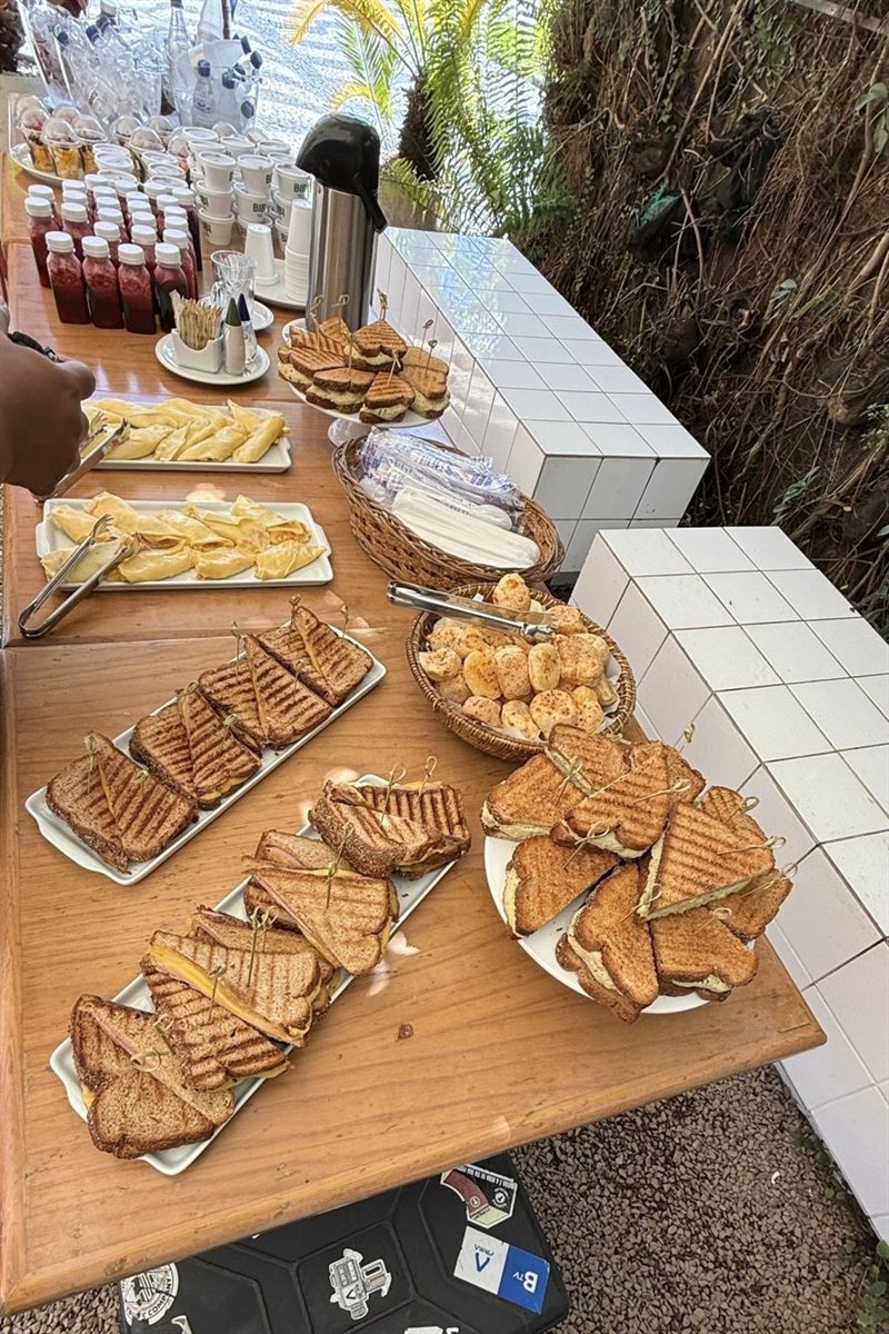 Mesa farta de sanduíches tostados servida em evento Bibi ao ar livre
