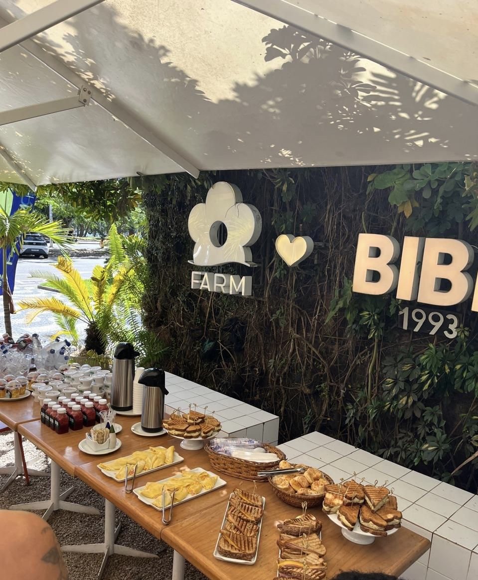 Coffee break da parceria FARM + Bibi 1993, com mesa posta em ambiente arborizado