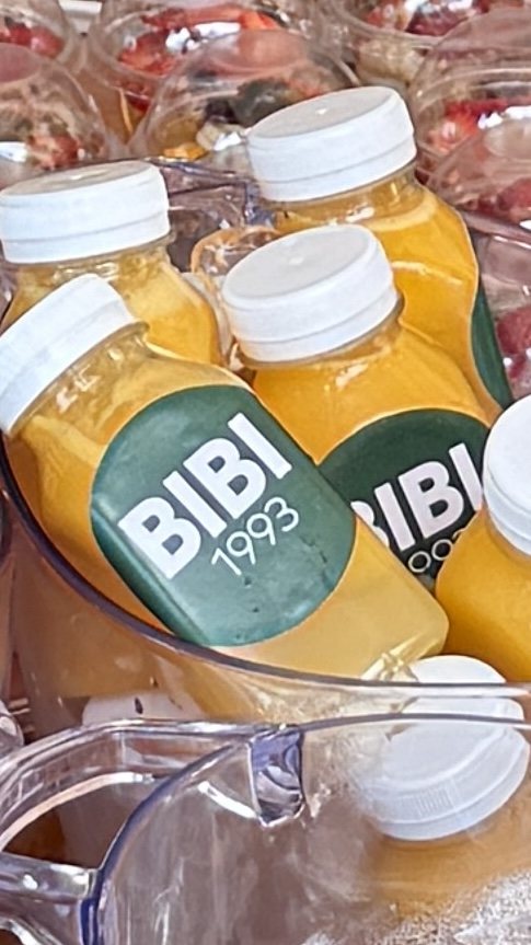 Garrafas de suco natural Bibi organizadas para servir em evento